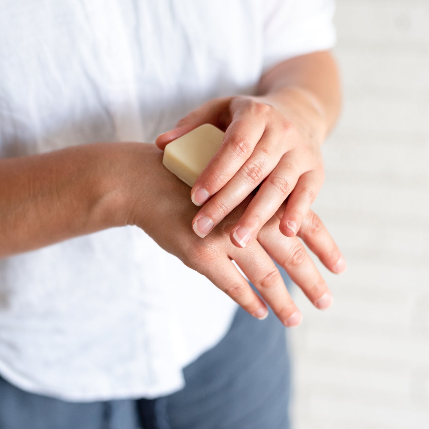 Hands applying Beeswax-based Beesilk Lotion Bar for dry skin