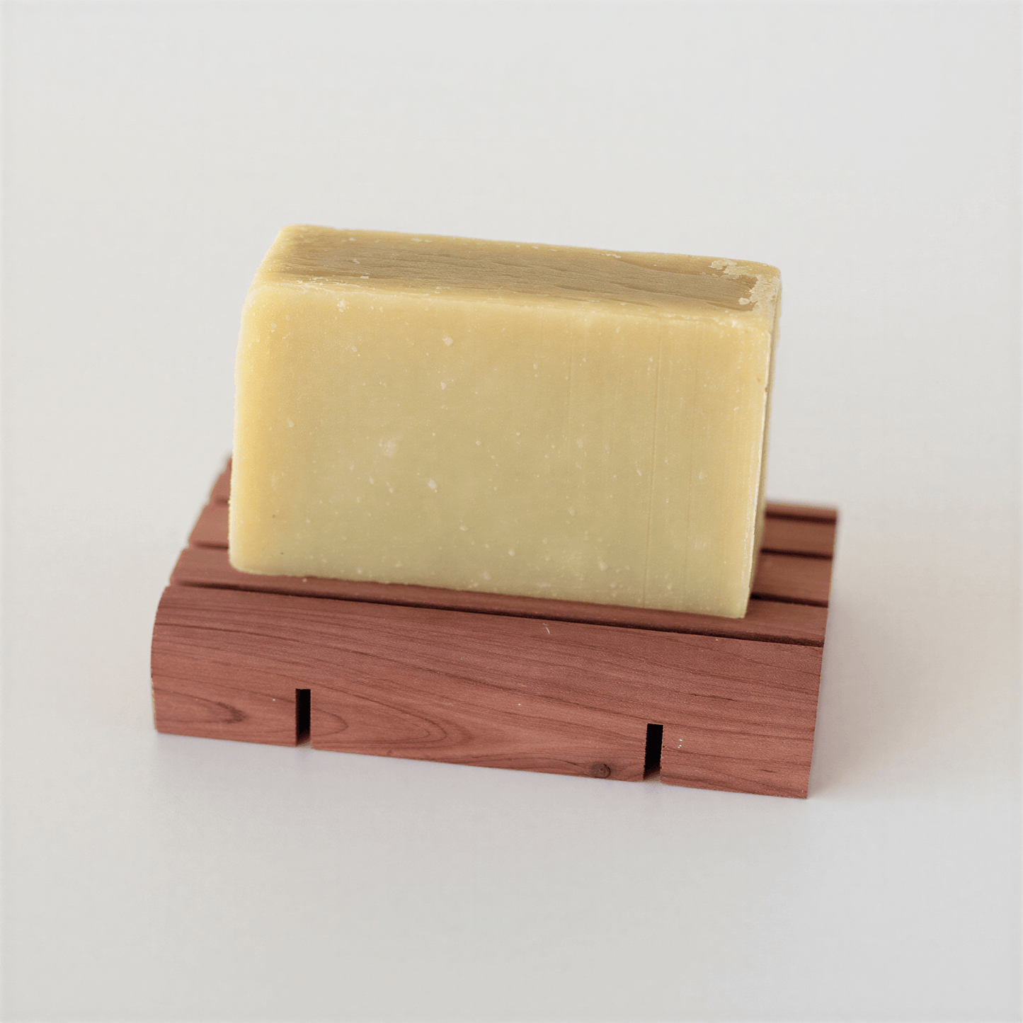 Avocado Facial Soap bar on a wood soap deck against a white background. Wood deck sold separately
