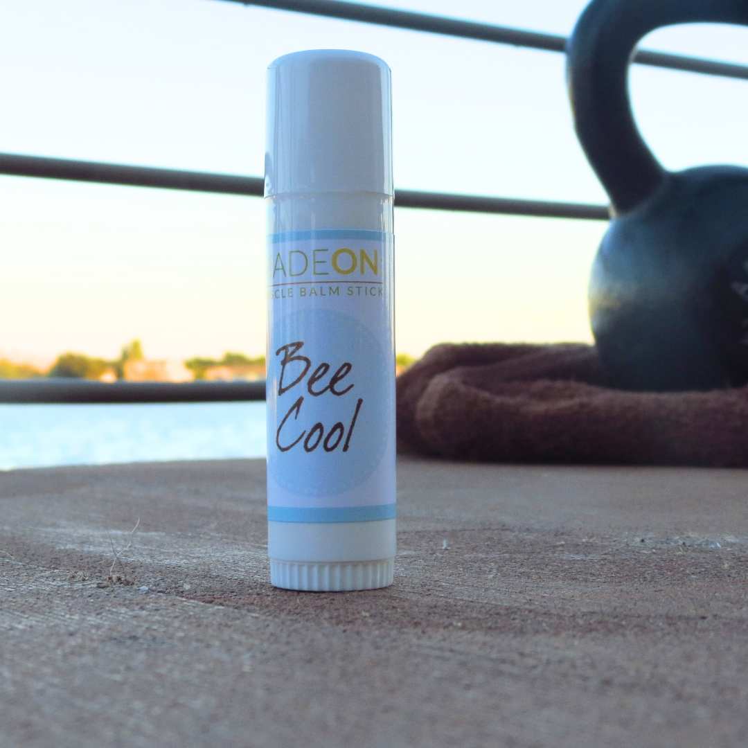 Beecool Muscle Balm lotion Stick next to kettlebell