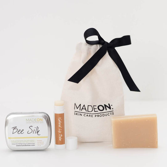 A gift bag with beeswax-based lotion bar, natural lip balm, and goat milk soap