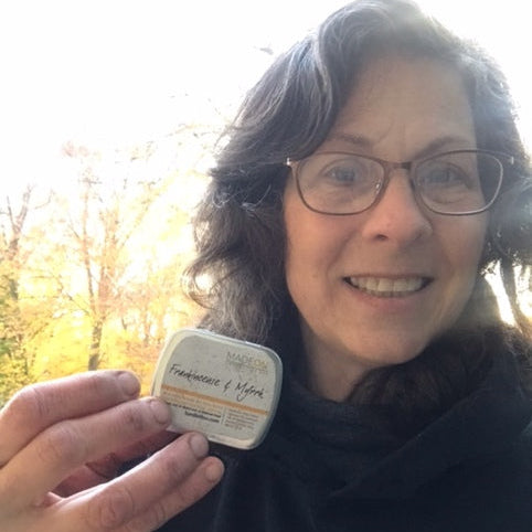 woman holding a scented lotion bar for dry skin while smiling