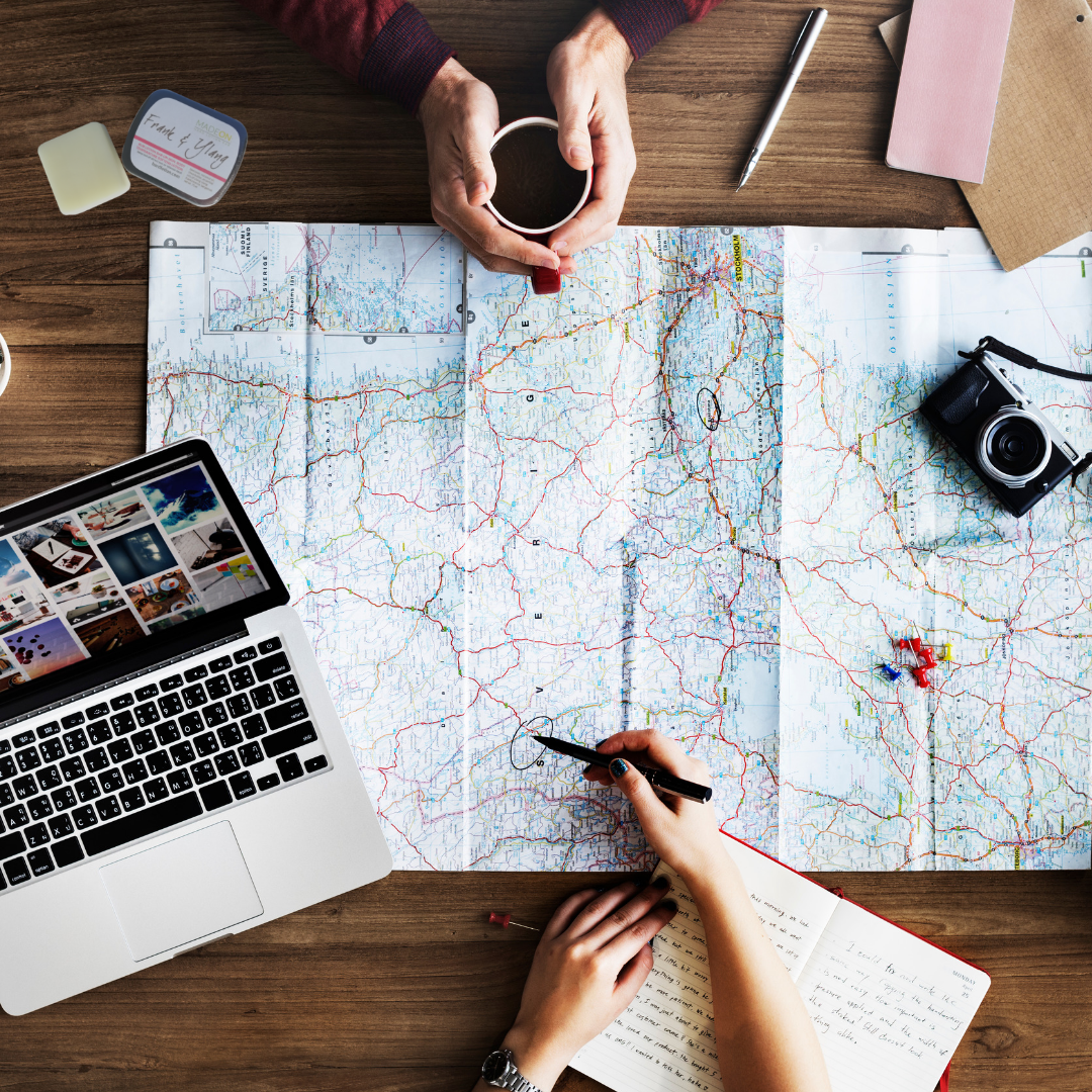 World map with travelers planning trip with lotion bar on the table