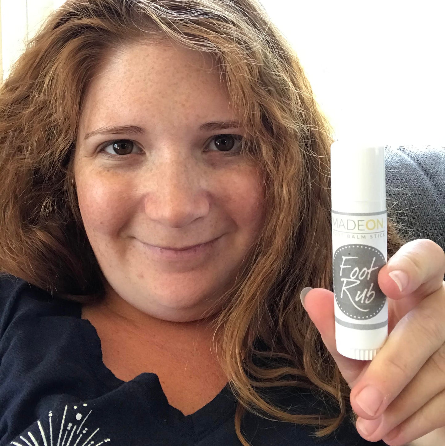 woman holding foot rub lotion stick for dry cracked feet and heels