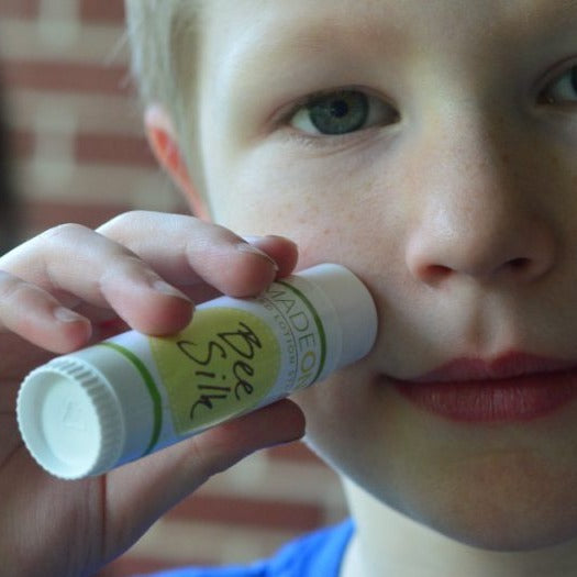 Boy applying beesilk lotion stick to face