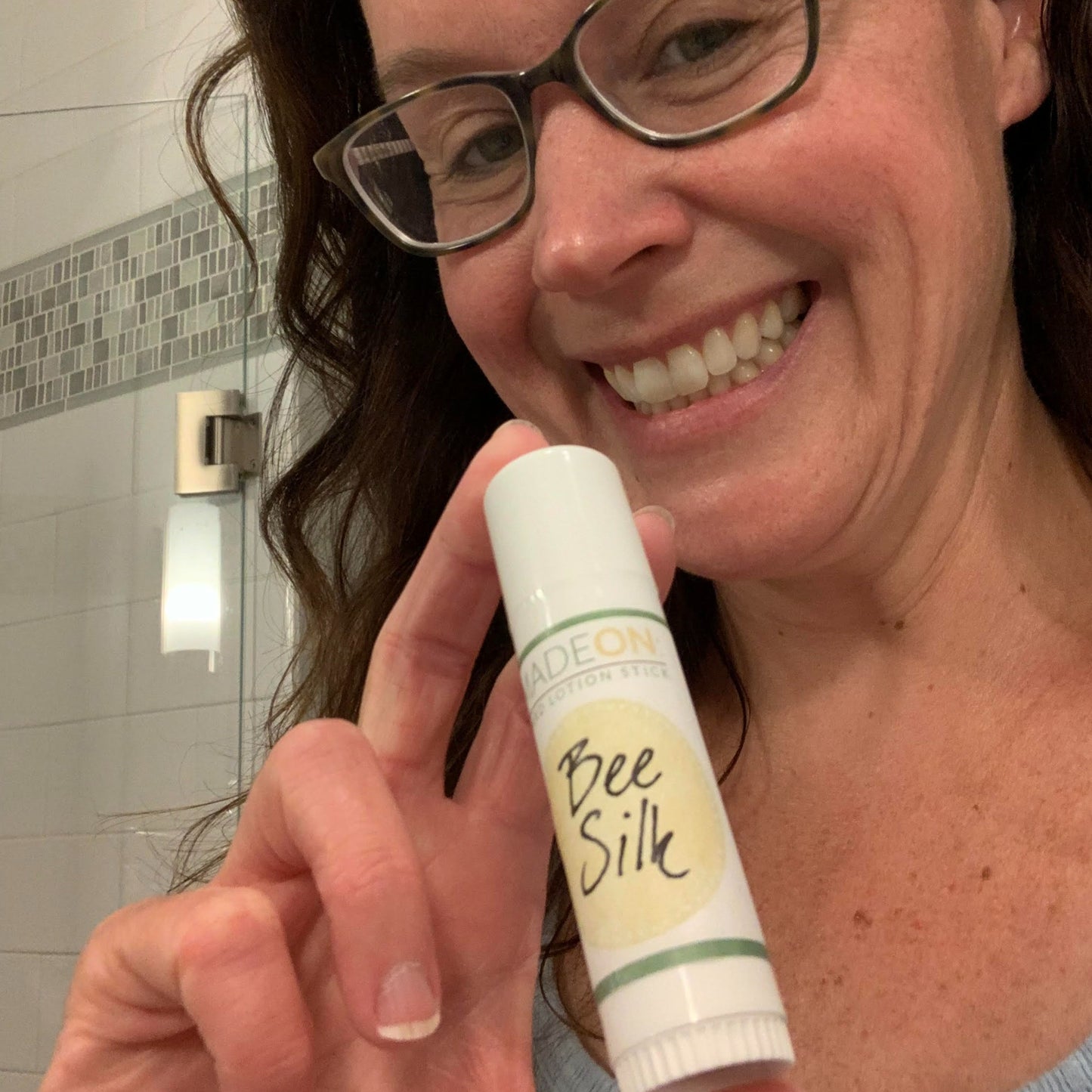 woman holding up beesilk lotion stick