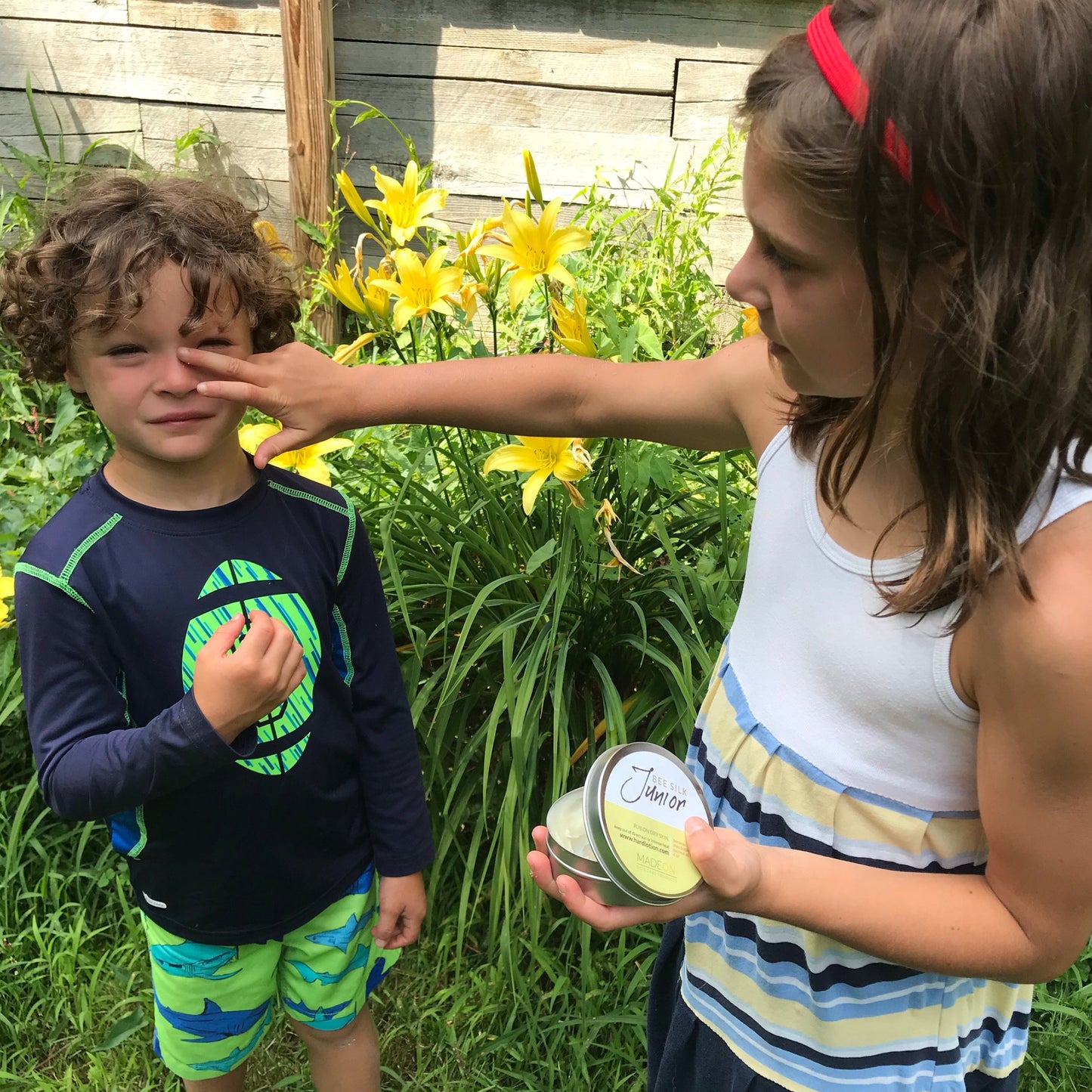 girl applying beesilk jr emollient for mild eczema to her brother's nose