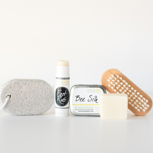 Dry, Cracked Feet Repair Kit against white background. Includes pumice stick, foot rub lotion bar stick, beesilk lotion bar and nail brush