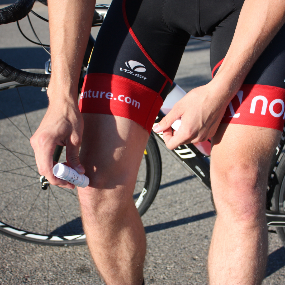 Male bicyclist applying BeeCool Muscle Rub Lotion Stick to his leg