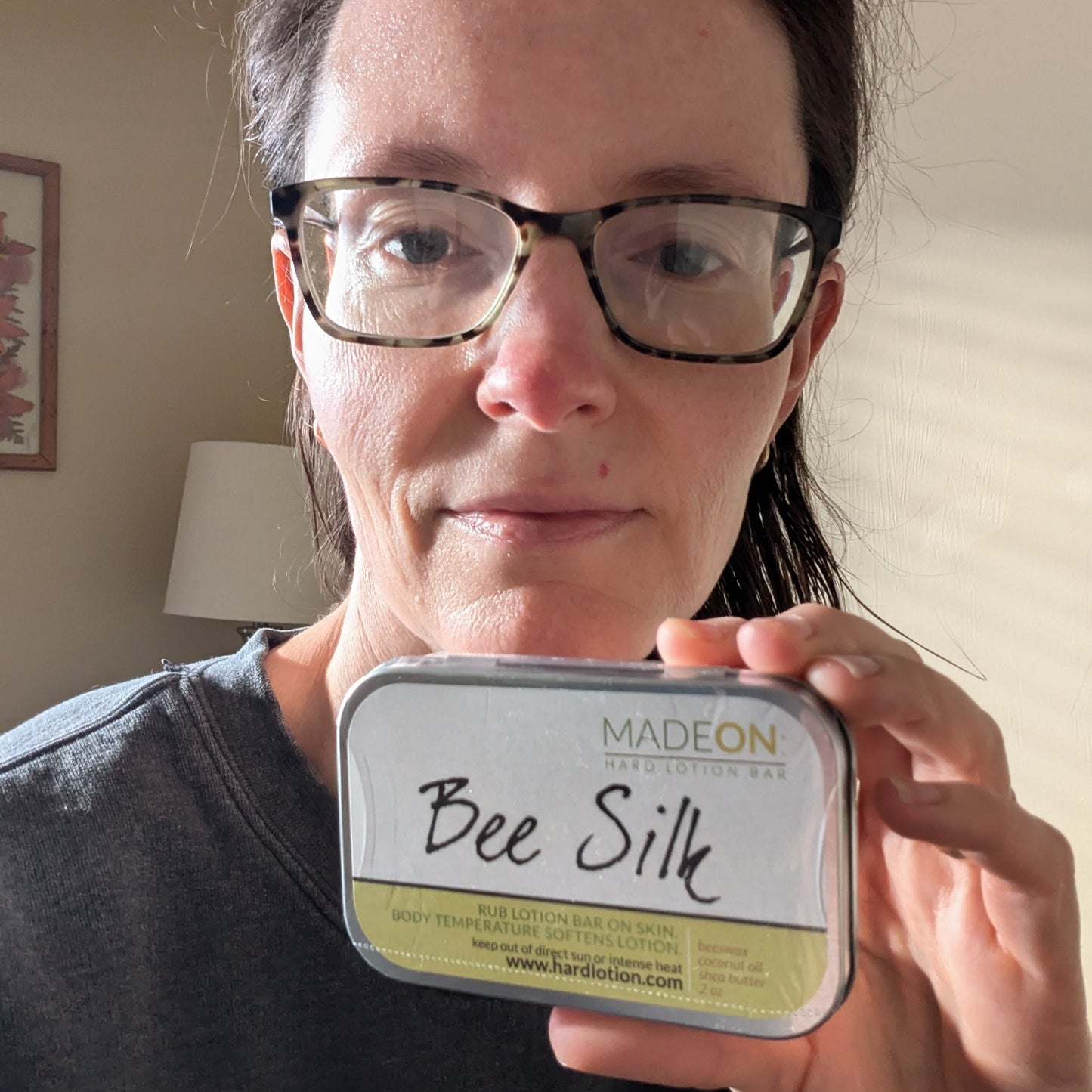 woman with a cold holding up beesilk lotion bar for dry skin