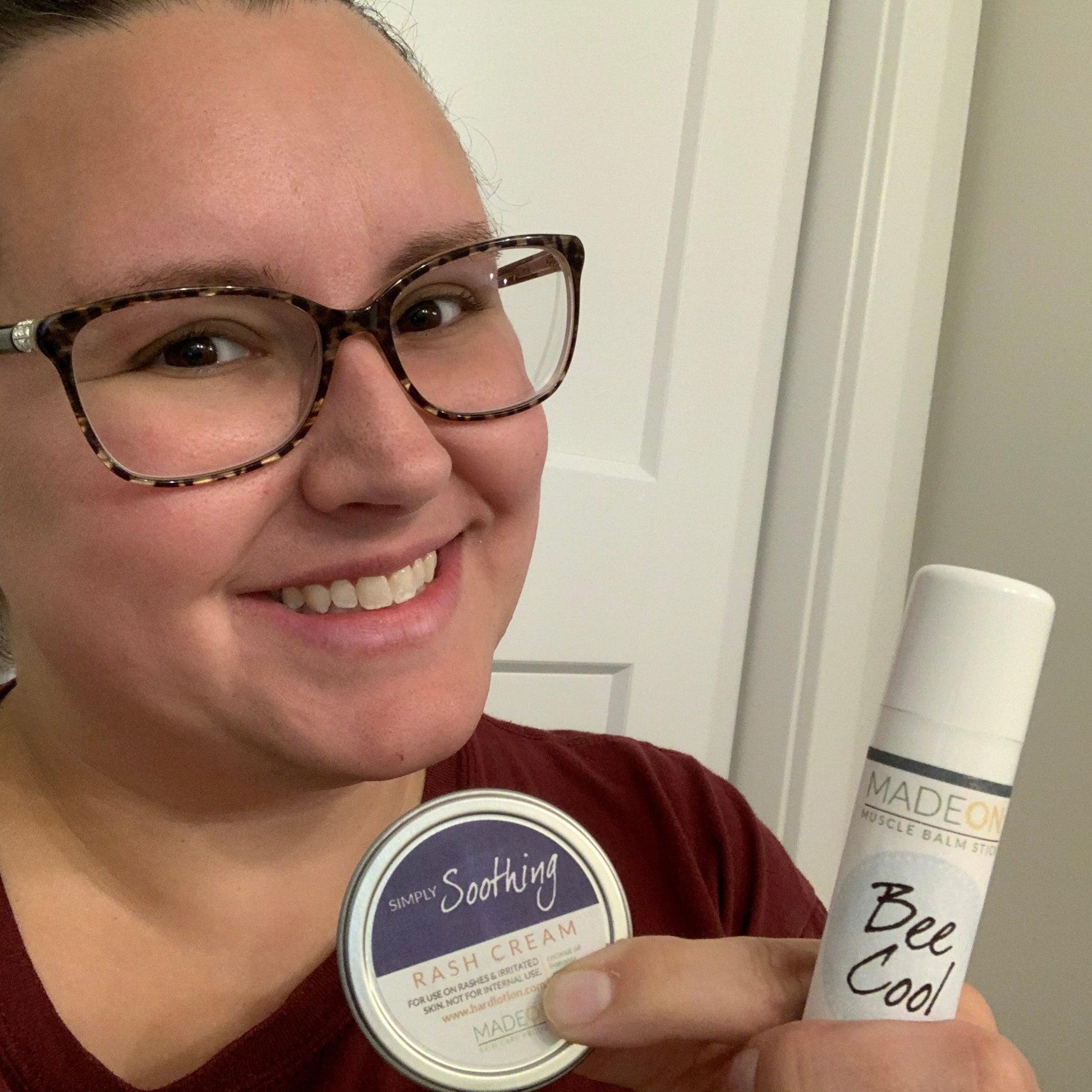 a woman with glasses holding a rash cream for her adult rash and a beecool menthol lotion stick for her winter skin