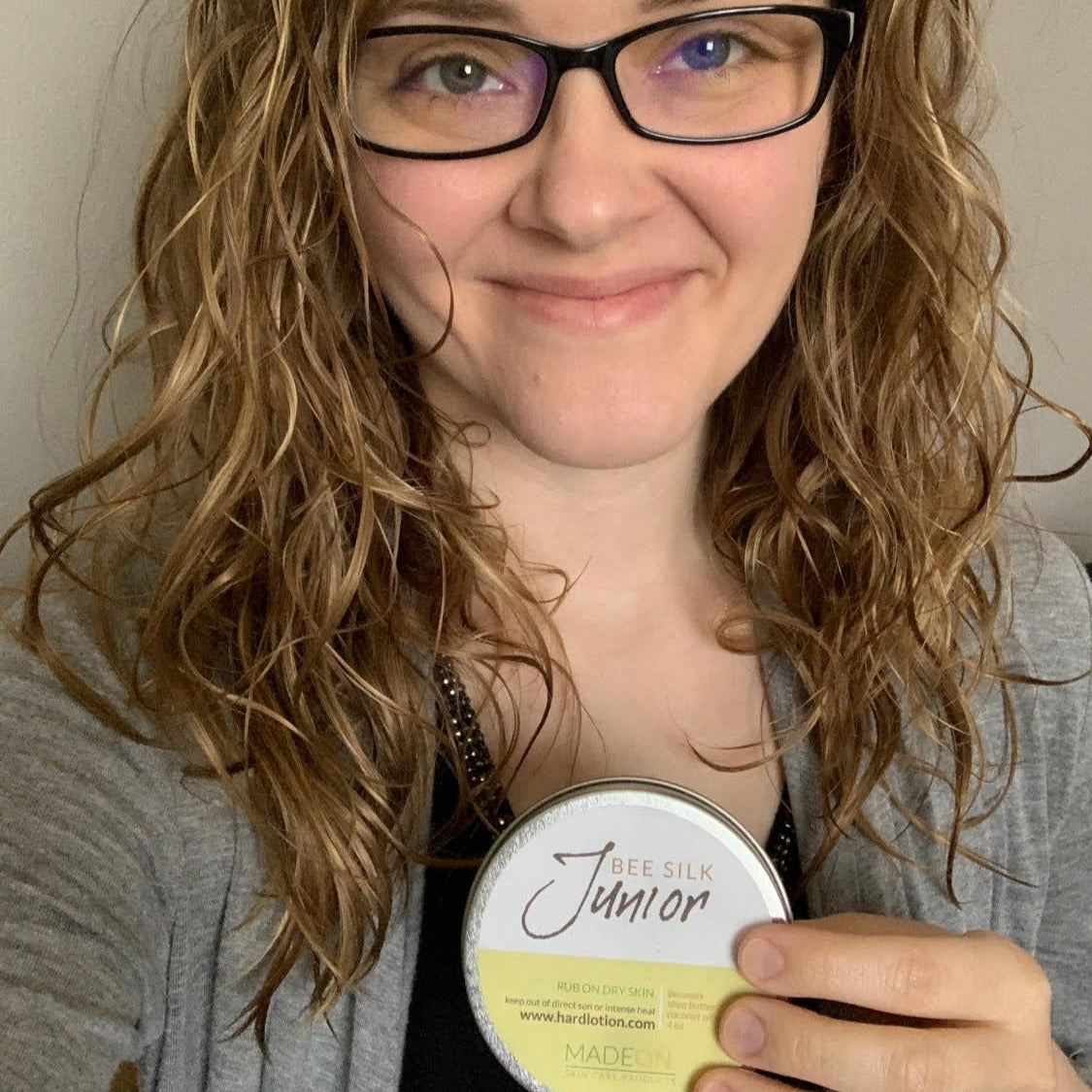 Woman holding tin of eczema treatment emollient