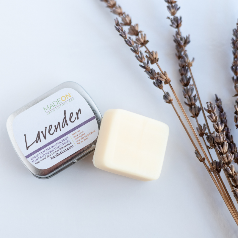Lavender Lotion Bar for dry skin with tin and real and lavender laying next to it
